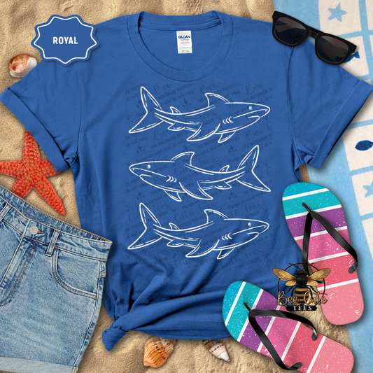Blue t-shirt with shark designs on a beach-themed background