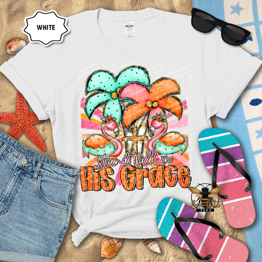 White t-shirt with colorful design and text 'stand tall in His Grace' on a beach-themed background.