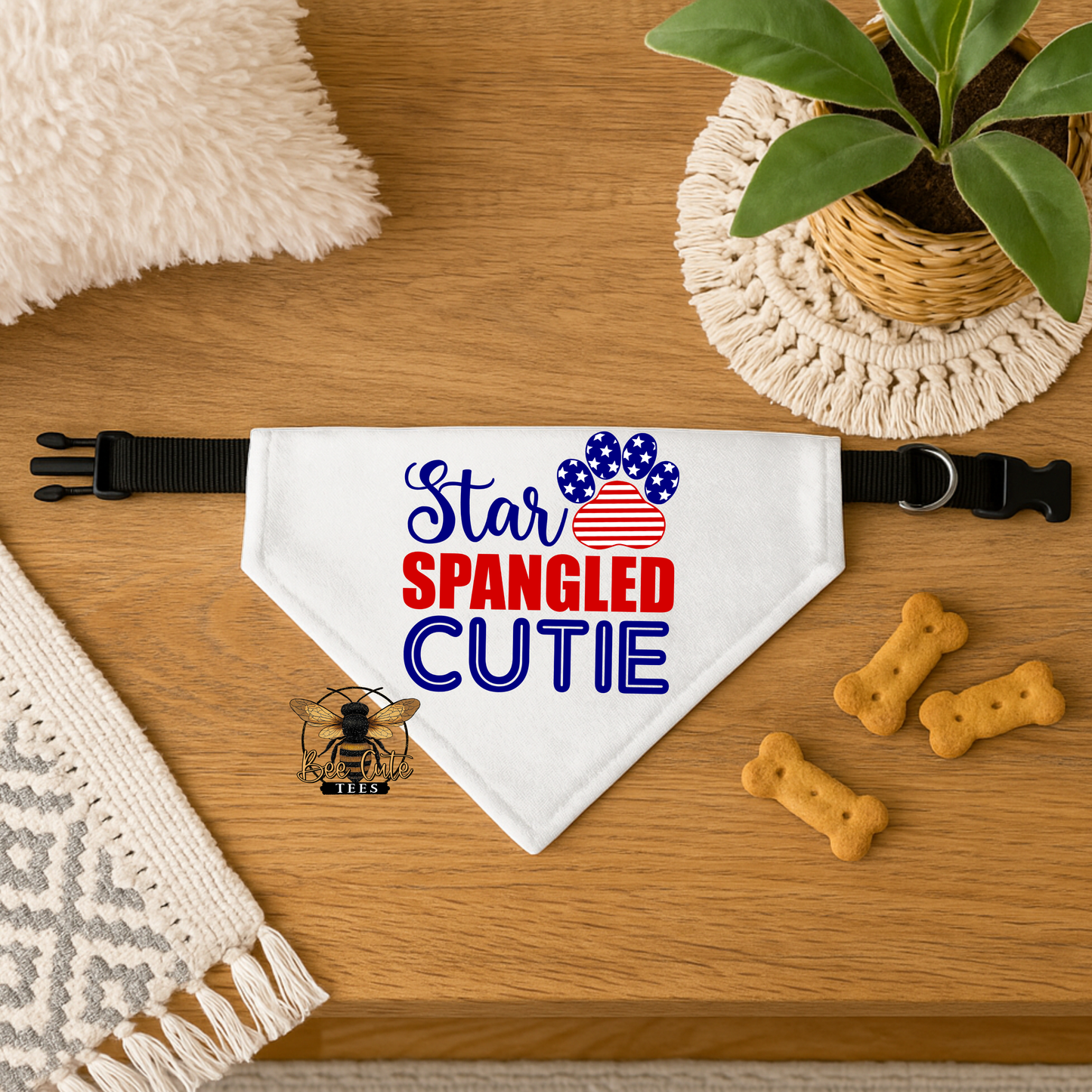 Dog bandana with 'Star Spangled Cutie' text on a wooden surface with treats and a plant.