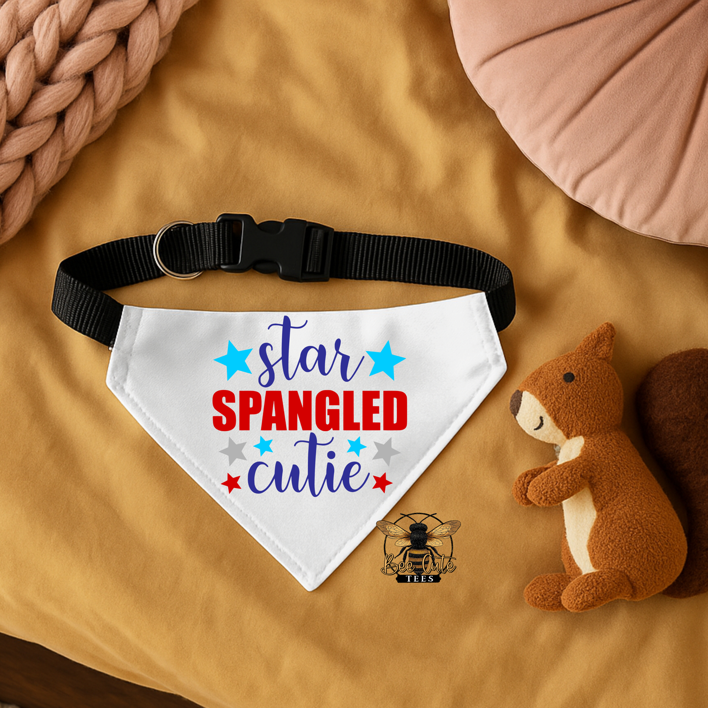 Dog bandana with 'Star Spangled Cutie' text on a brown surface with a plush toy.