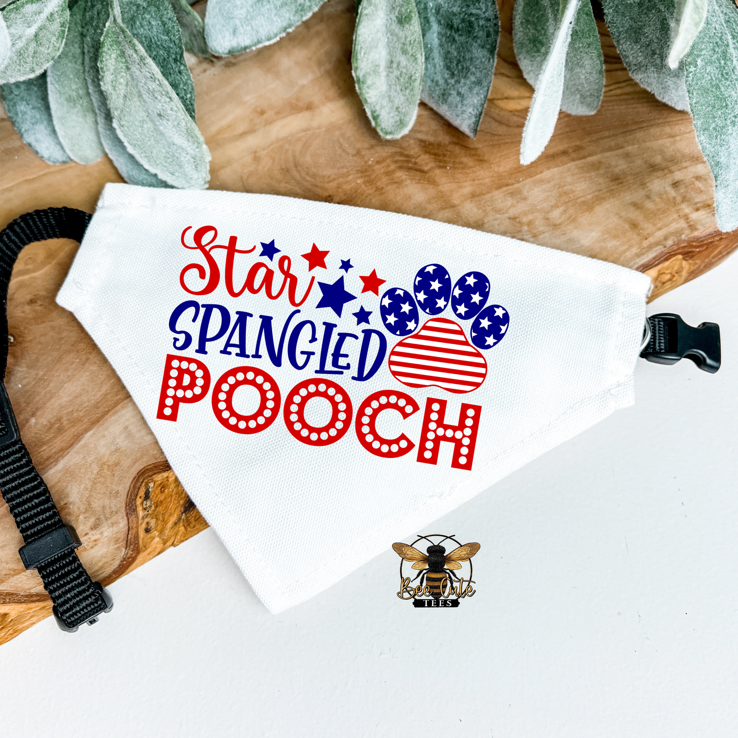 Dog bandana with 'Star Spangled Pooch' text and American flag design on a wooden surface.