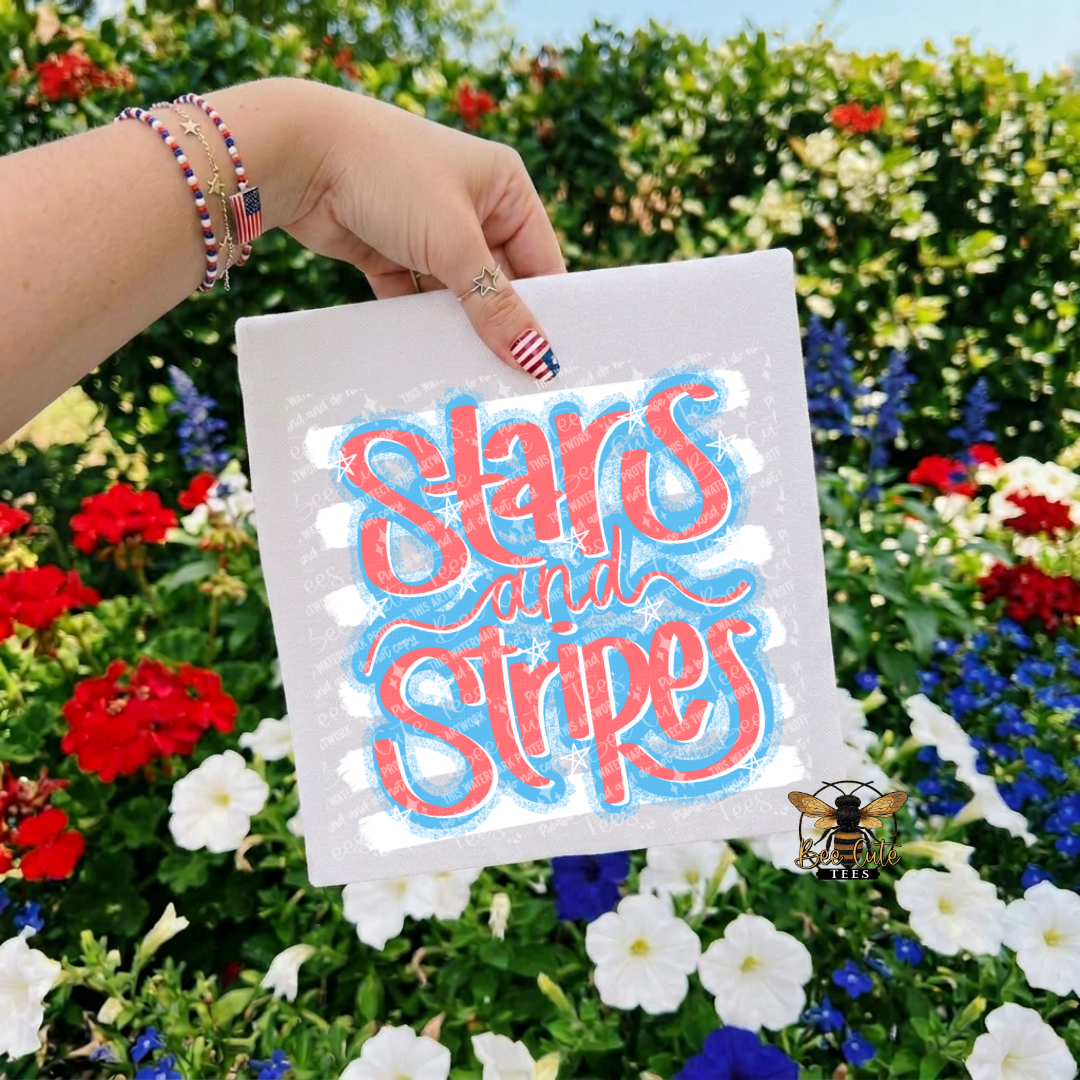 Hand holding a white t-shirt with 'Stars and Stripes' text against a floral background