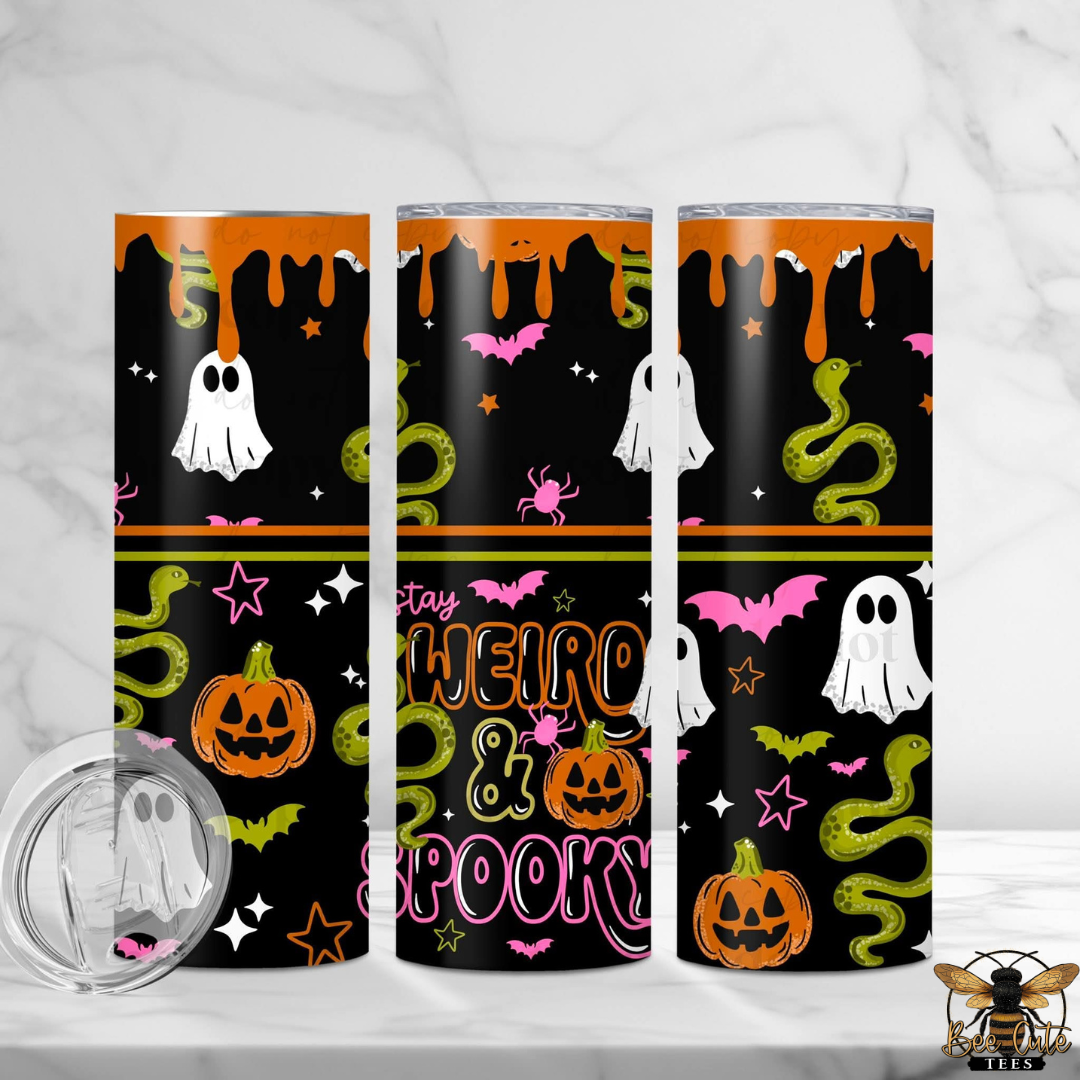 Three tall skinny tumblers with a Halloween-themed wrap design, shown on a white marble surface with a marble background. The design features a black background with orange dripping paint, white ghosts, green snakes, pink bats and spiders, orange jack-o'-lanterns, and the text 'Stay WEIRD & SPOOKY'.