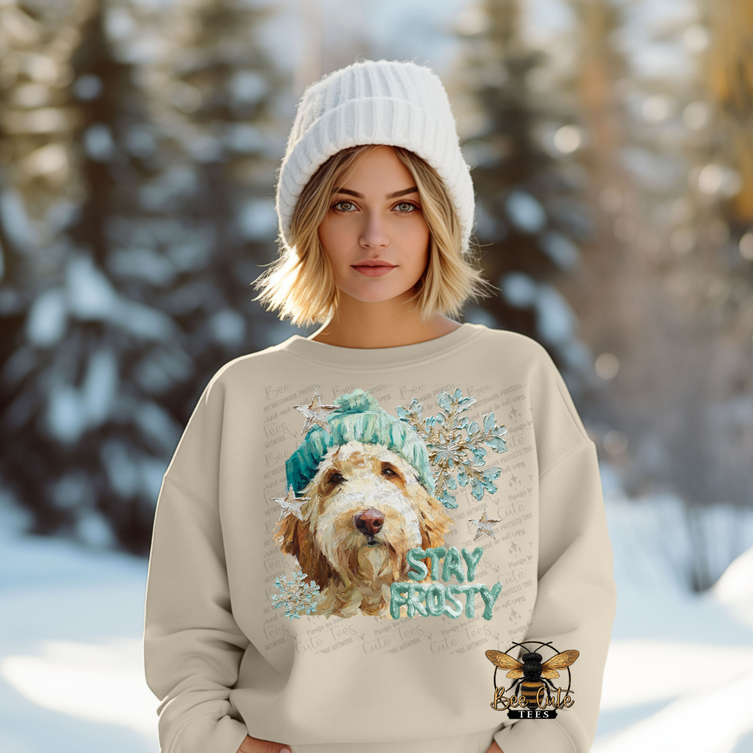 Person wearing a beige sweater with a dog graphic and 'Stay Frosty' text in a snowy landscape.