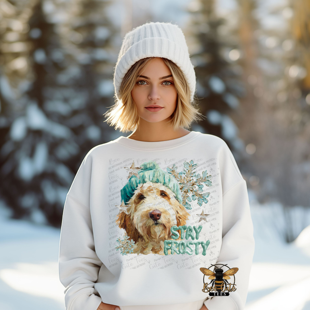Woman wearing a sweater with a dog graphic and 'Stay Frosty' text in a snowy landscape