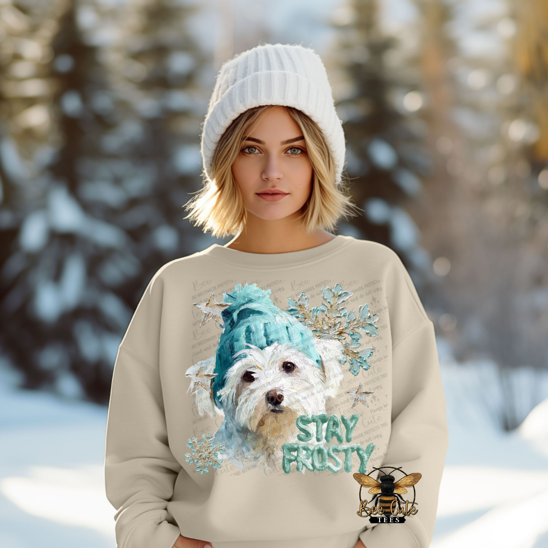 Person wearing a sweater with a dog graphic and 'Stay Frosty' text in a snowy background