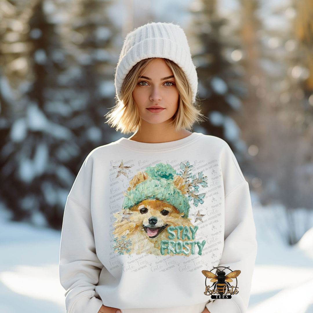 Person wearing a sweater with a dog graphic and 'Stay Frosty' text in a snowy landscape