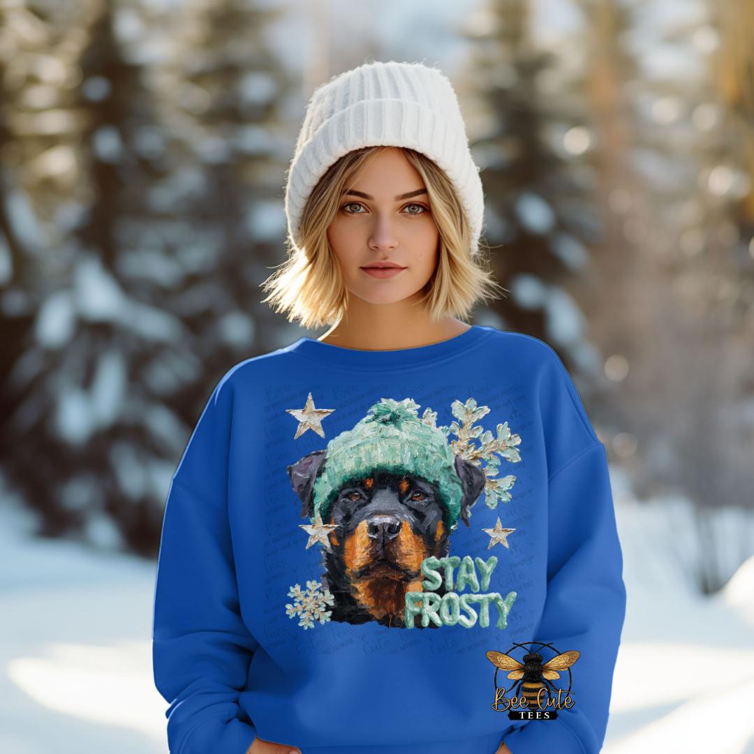 Person wearing a blue sweater with a dog graphic and 'Stay Frosty' text in a snowy landscape.