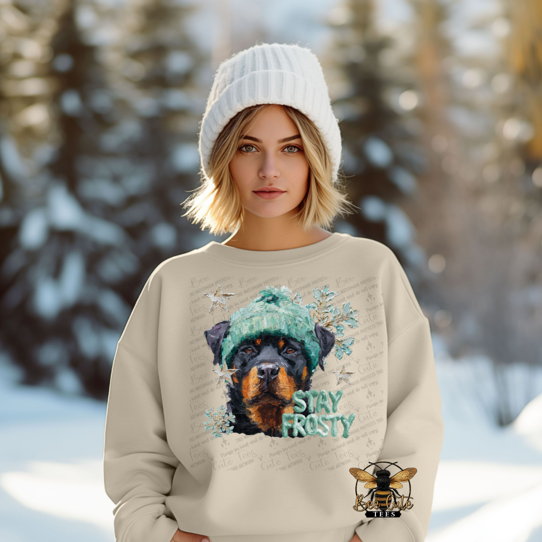 Woman wearing a sweater with a dog graphic and 'Stay Frosty' text in a snowy forest setting
