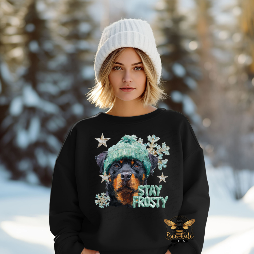 Person wearing a black sweater with a dog graphic and 'Stay Frosty' text in a snowy forest setting