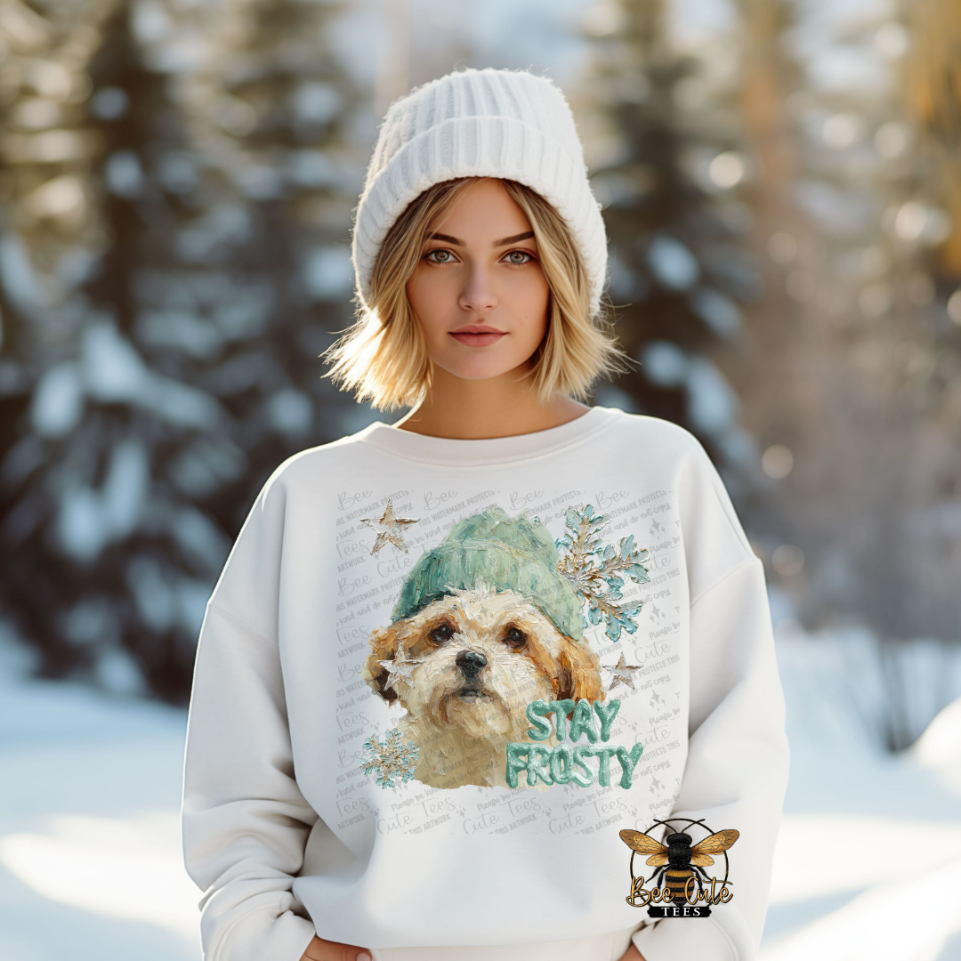 Person wearing a sweater with a dog graphic and 'Stay Frosty' text in a snowy landscape
