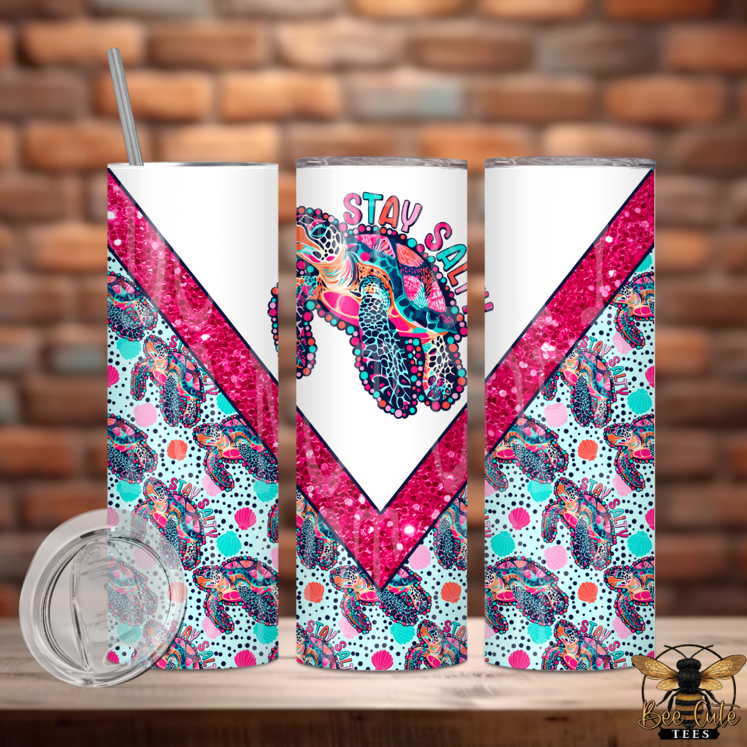 Three colorful tumblers with geometric patterns and text on a wooden surface with a brick wall background.