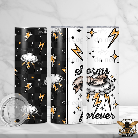 Three insulated tumblers with matching clear lids are displayed on a light marble surface. The left tumbler is black with orange and white lightning bolts, stars, and clouds; the center tumbler shows a black-and-white split design with orange lightning bolts and white stars; the right tumbler is white with black script reading 'Storms do not last forever,' gray clouds, and orange lightning bolts.
