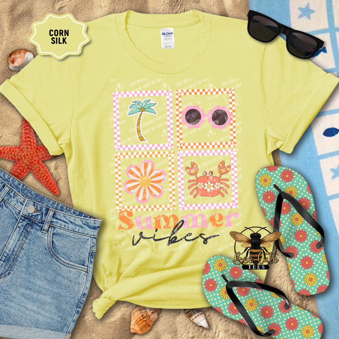 Yellow t-shirt with summer-themed design, sunglasses, flip-flops, and beach accessories on a sandy background.