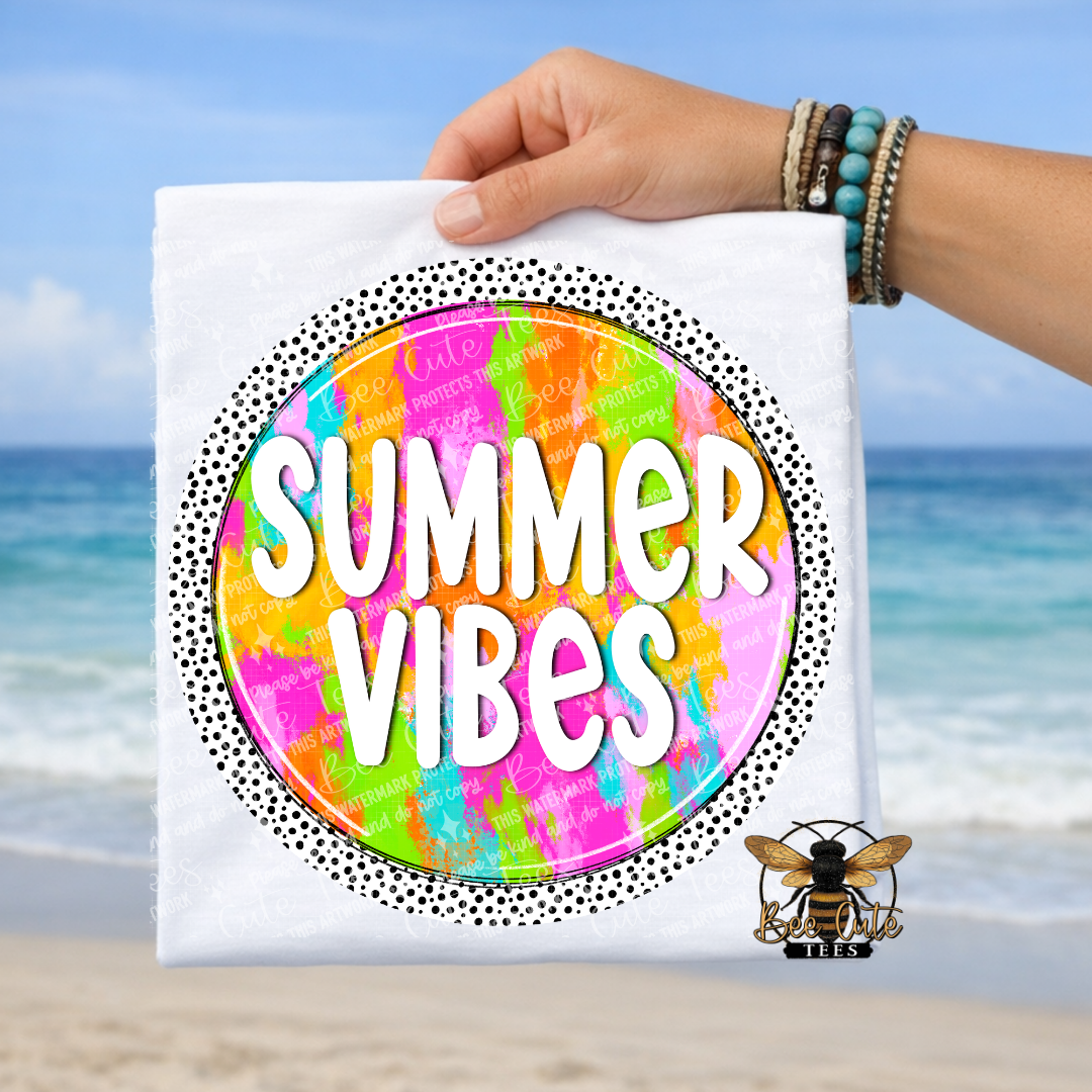Hand holding a t-shirt with 'Summer Vibes' text against a beach background