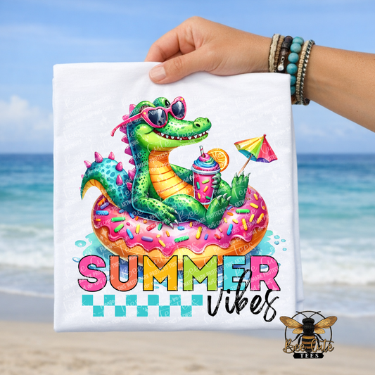 Colorful alligator on a donut float with 'Summer Vibes' text, held against a beach background.