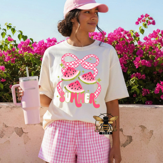 Person wearing a white t-shirt with a summer-themed design, pink shorts, and a pink cap, holding a pink cup with a bee logo.