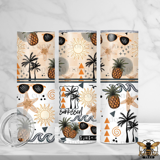 Three tumblers with tropical designs featuring pineapples, palm trees, and sunglasses on a white background.