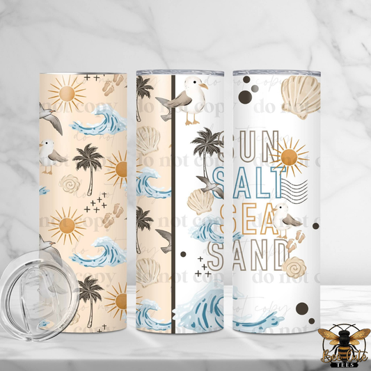 Three tumblers with beach-themed designs on a white background