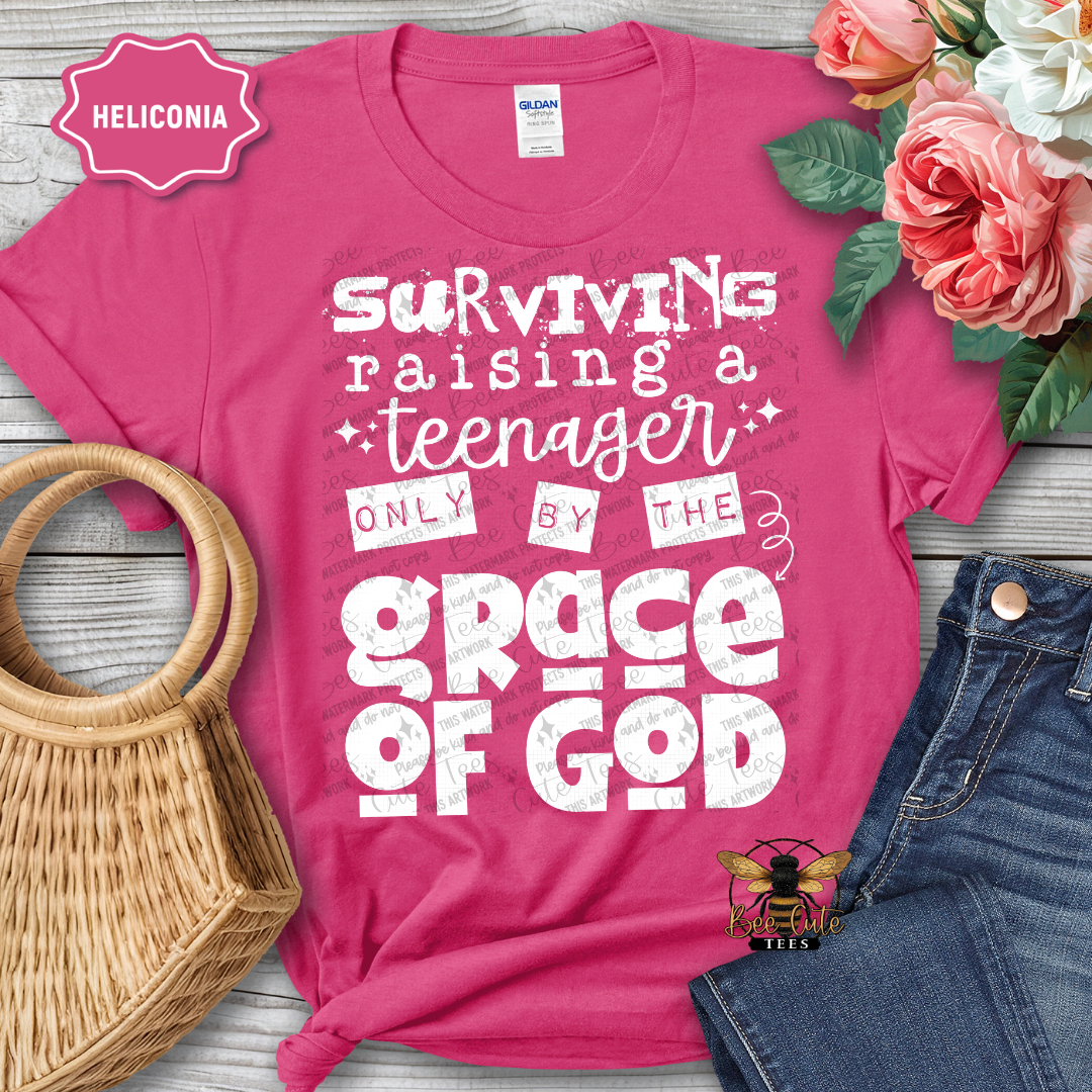 Pink t-shirt with humorous text design on a wooden surface with flowers and denim jeans.
