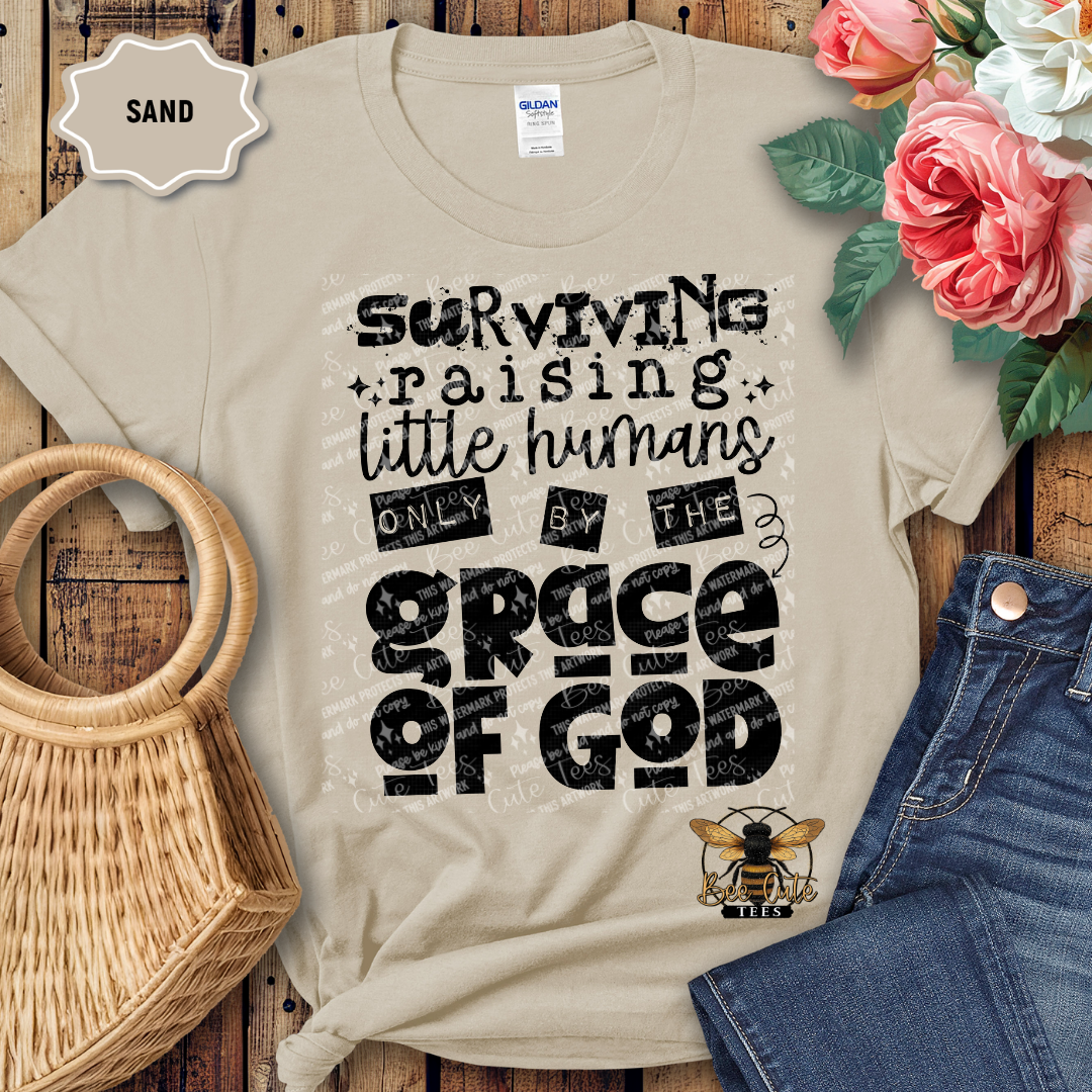 Beige t-shirt with text design on a wooden surface with flowers and jeans.