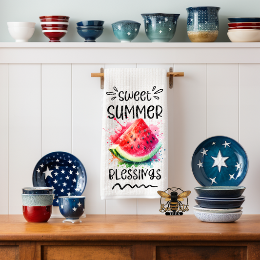 Kitchen setting with colorful bowls, plates, and a towel with 'Sweet Summer Blessings' text.