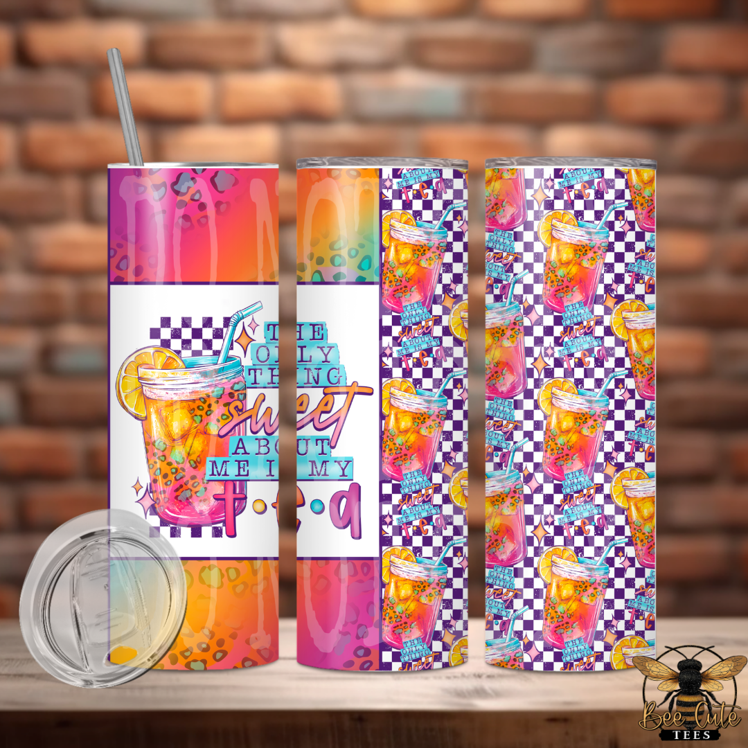 Three colorful tumblers with drink designs and text on a wooden surface with a brick wall background.