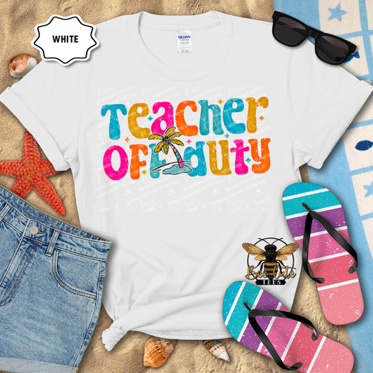 White t-shirt with 'Teacher Off Duty' text, sunglasses, denim shorts, and flip-flops on a sandy background.
