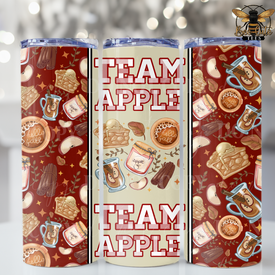 Three views of a 20 oz insulated tumbler with a 'Team Apple' design. The tumbler features a warm red-brown background pattern decorated with illustrations of apple cider, apple pie, cinnamon, and apple slices, alongside the text 'TEAM APPLE' in a distressed white font.