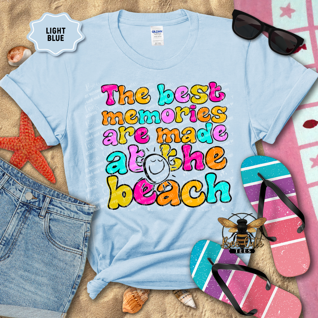 Light blue t-shirt with colorful beach-themed text, surrounded by beach accessories.
