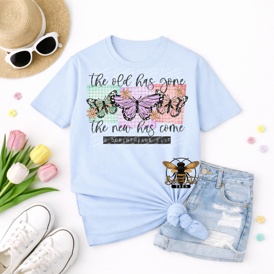 Light blue t-shirt with butterfly design and text, surrounded by accessories on a white background