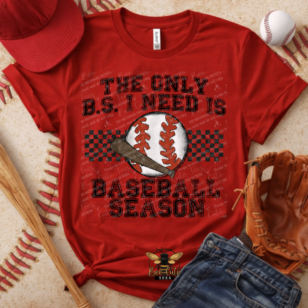 Red t-shirt with baseball-themed text, surrounded by baseball equipment on a textured surface.