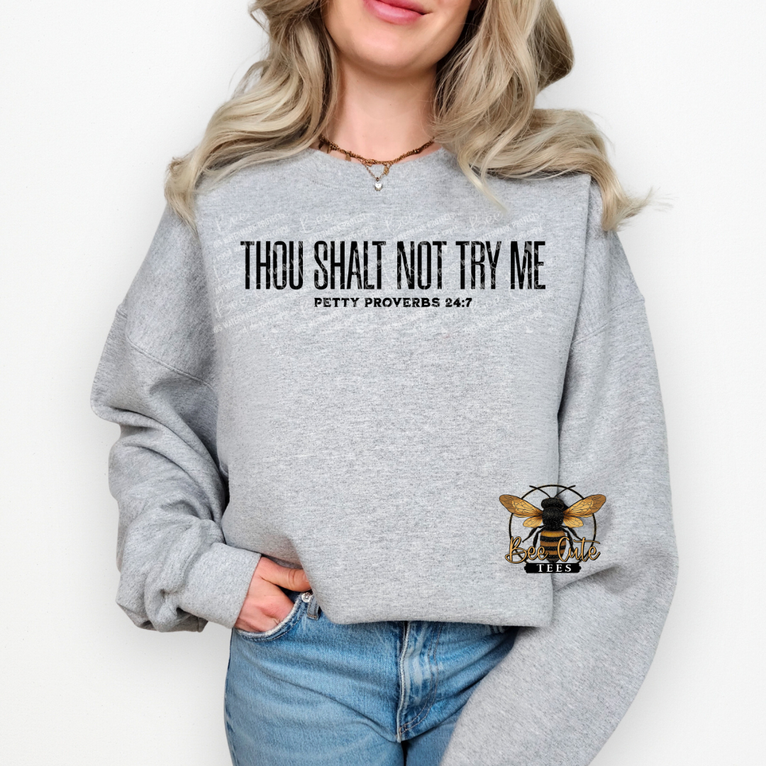 Person wearing a gray sweatshirt with text and a bee logo on a white background