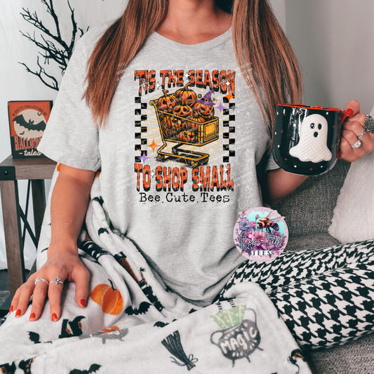 Person wearing a Halloween-themed t-shirt with pumpkins and text, holding a mug with a ghost design.