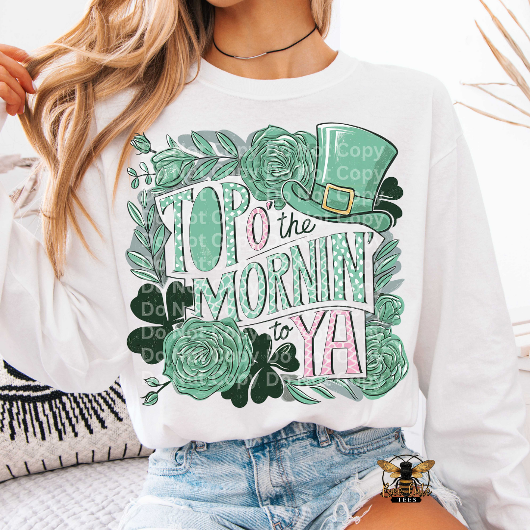 Person wearing a white sweatshirt with green floral design and text.