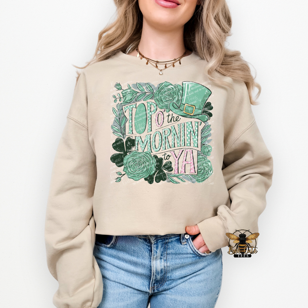 Person wearing a beige sweatshirt with decorative text and graphics on a white background