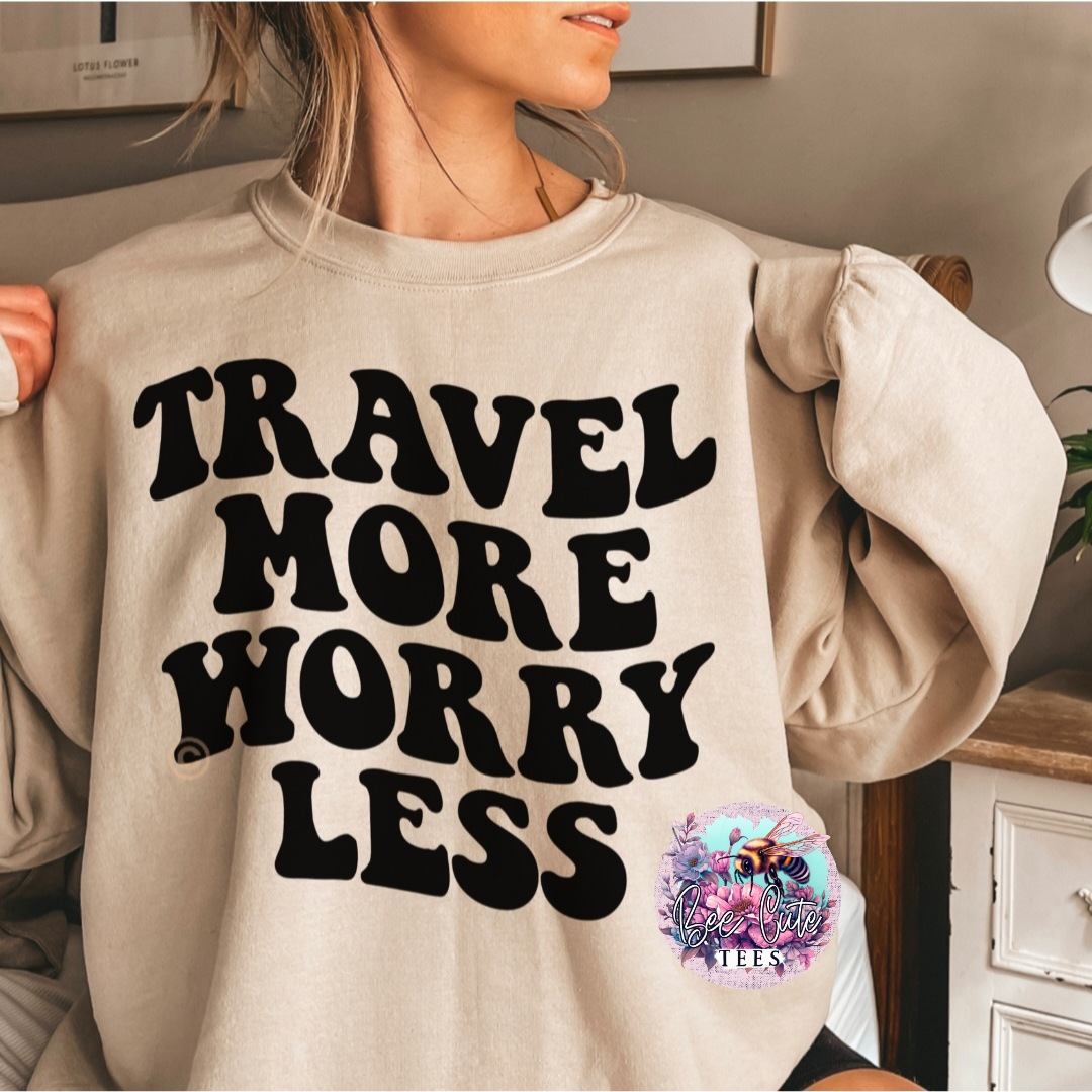 Person wearing a beige sweatshirt with 'Travel More Worry Less' text in a home setting.