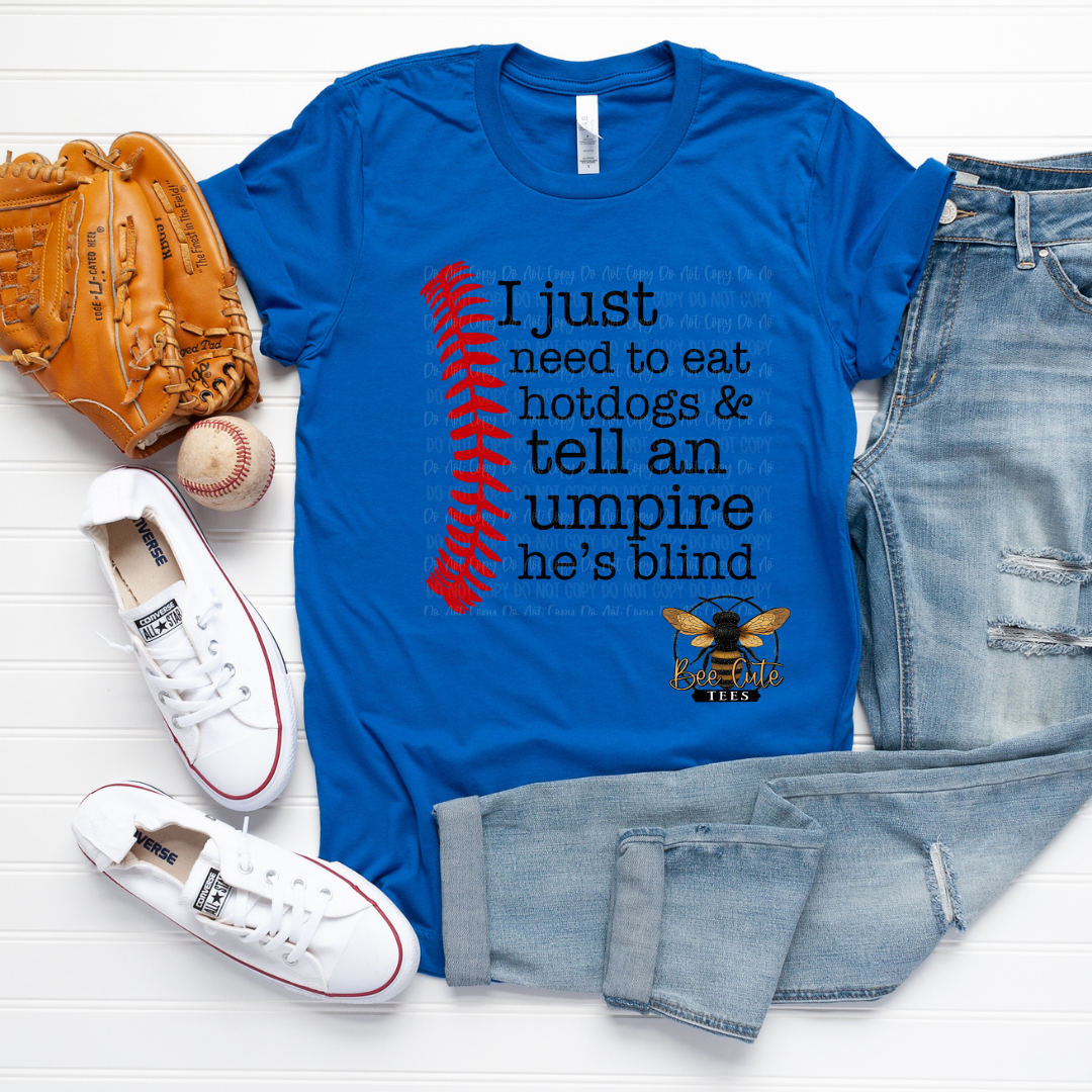Blue t-shirt with a graphic and text, surrounded by a baseball, glove, and jeans on a white background
