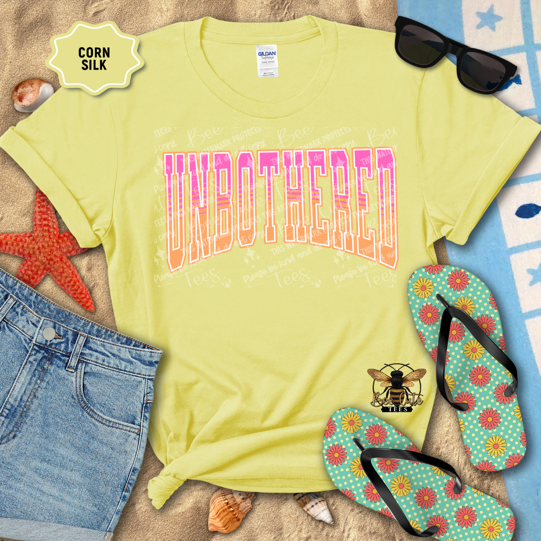 Yellow t-shirt with 'UNBOTHERED' text, sunglasses, denim shorts, and flip-flops on a beach-themed background.