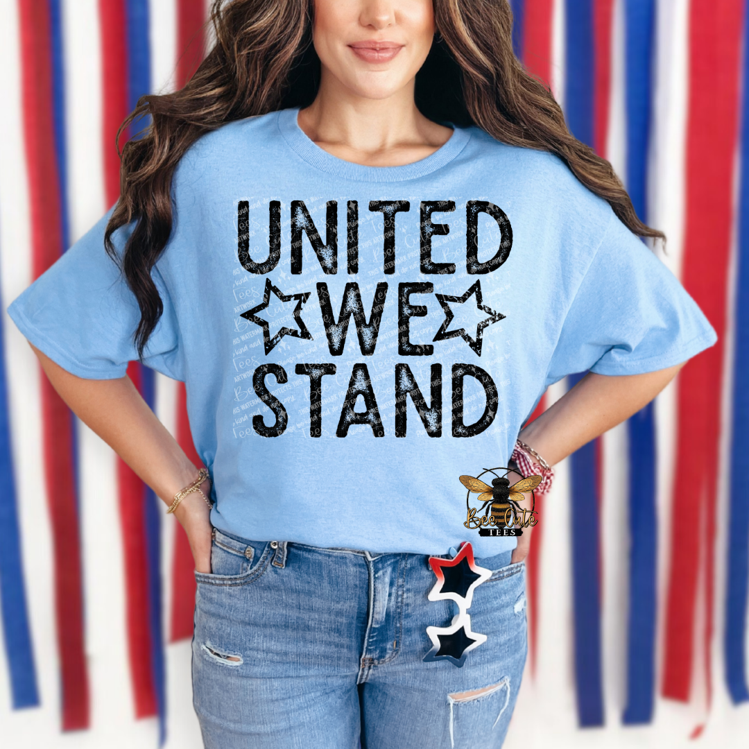 Person wearing a blue t-shirt with 'UNITED WE STAND' text against a colorful striped background