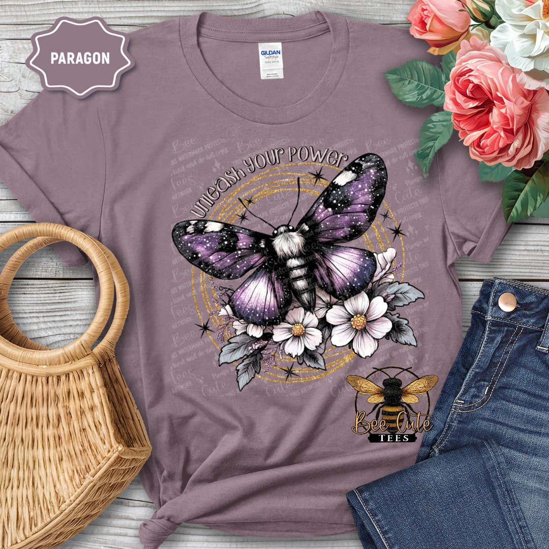Purple t-shirt with butterfly and floral design, placed on a wooden surface with flowers and denim jeans.