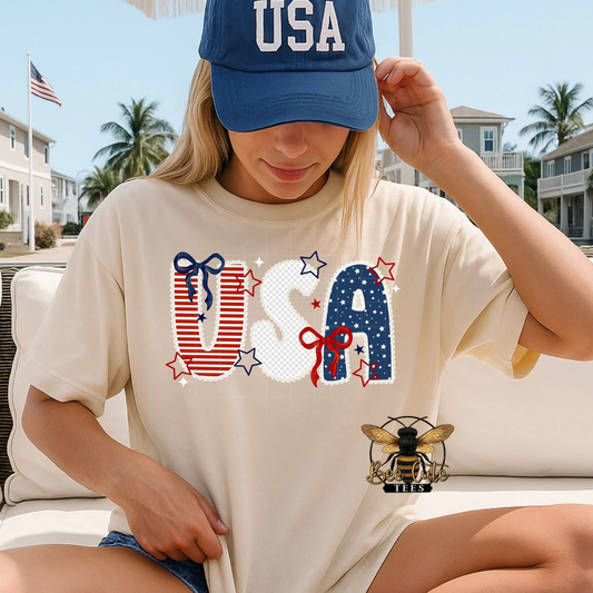 Person wearing a 'USA' t-shirt and cap outdoors