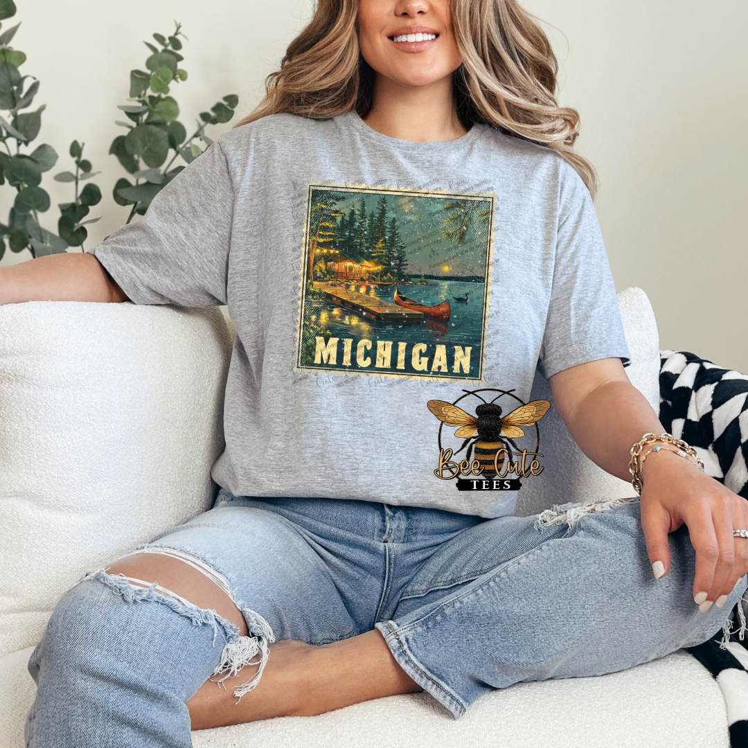 Person wearing a gray t-shirt with a 'Michigan' graphic design sitting on a couch.