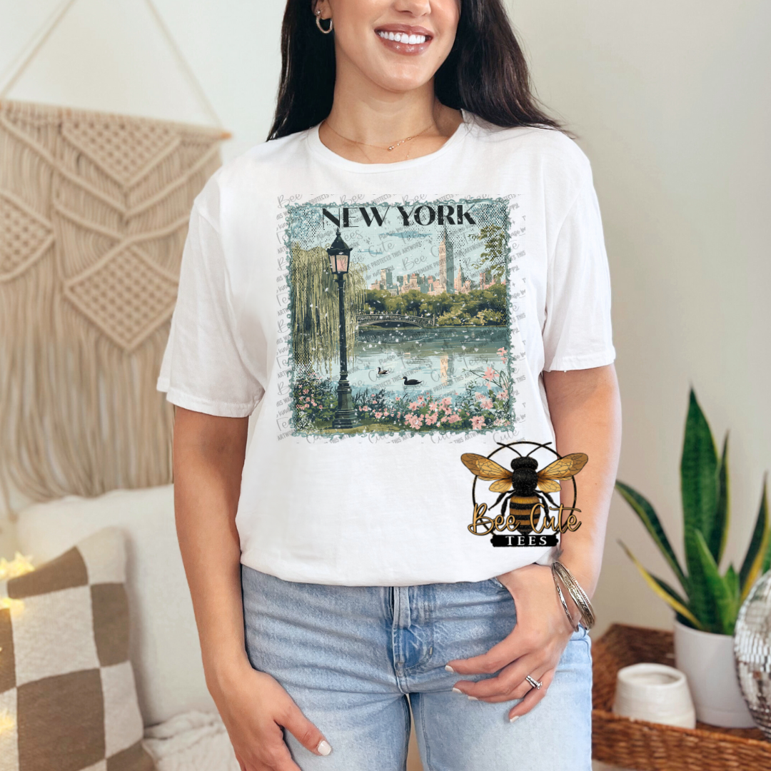 Person wearing a white t-shirt with a New York graphic design in a casual setting.