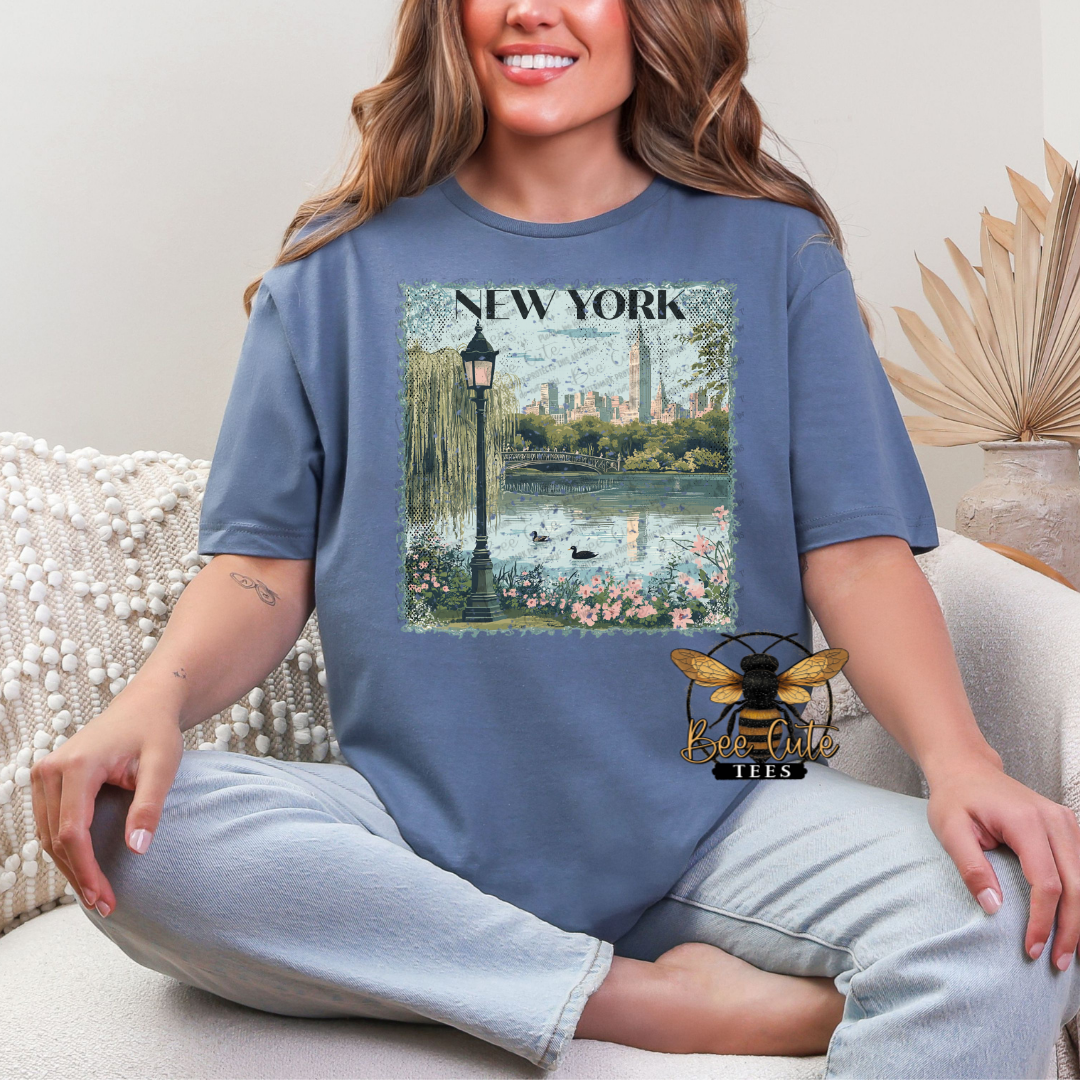 Person wearing a blue t-shirt with a New York City graphic design.