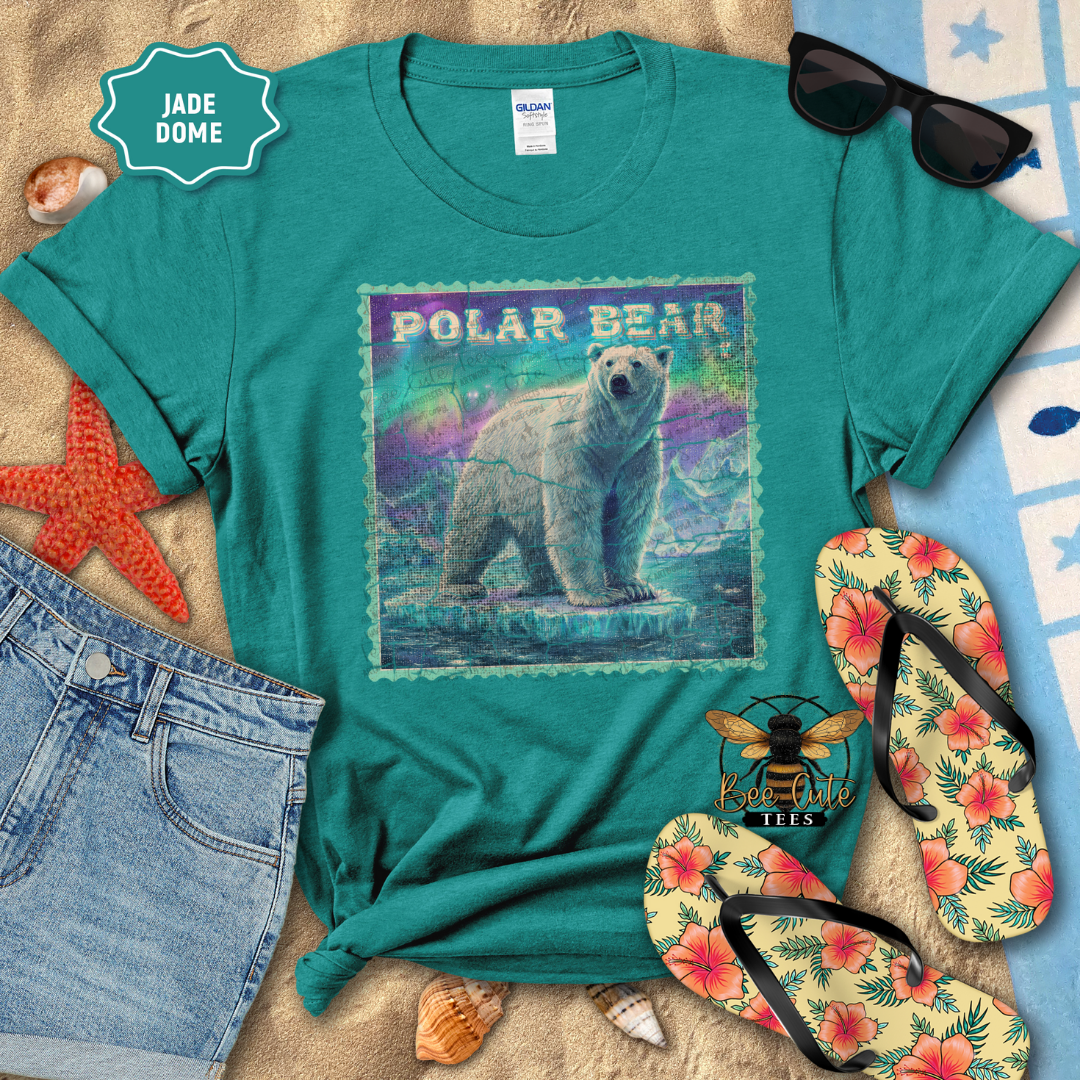 Teal t-shirt with polar bear graphic on a beach-themed background with sunglasses, flip-flops, and denim shorts.