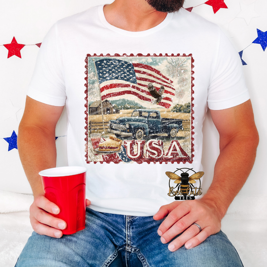 Person wearing a white t-shirt with a patriotic design, holding a red cup.
