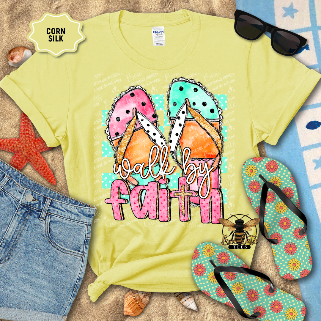 Yellow t-shirt with 'walk by faith' design, sunglasses, denim shorts, and flip-flops on a textured surface.
