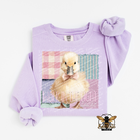 Lavender sweatshirt with a duckling graphic and text on a white background