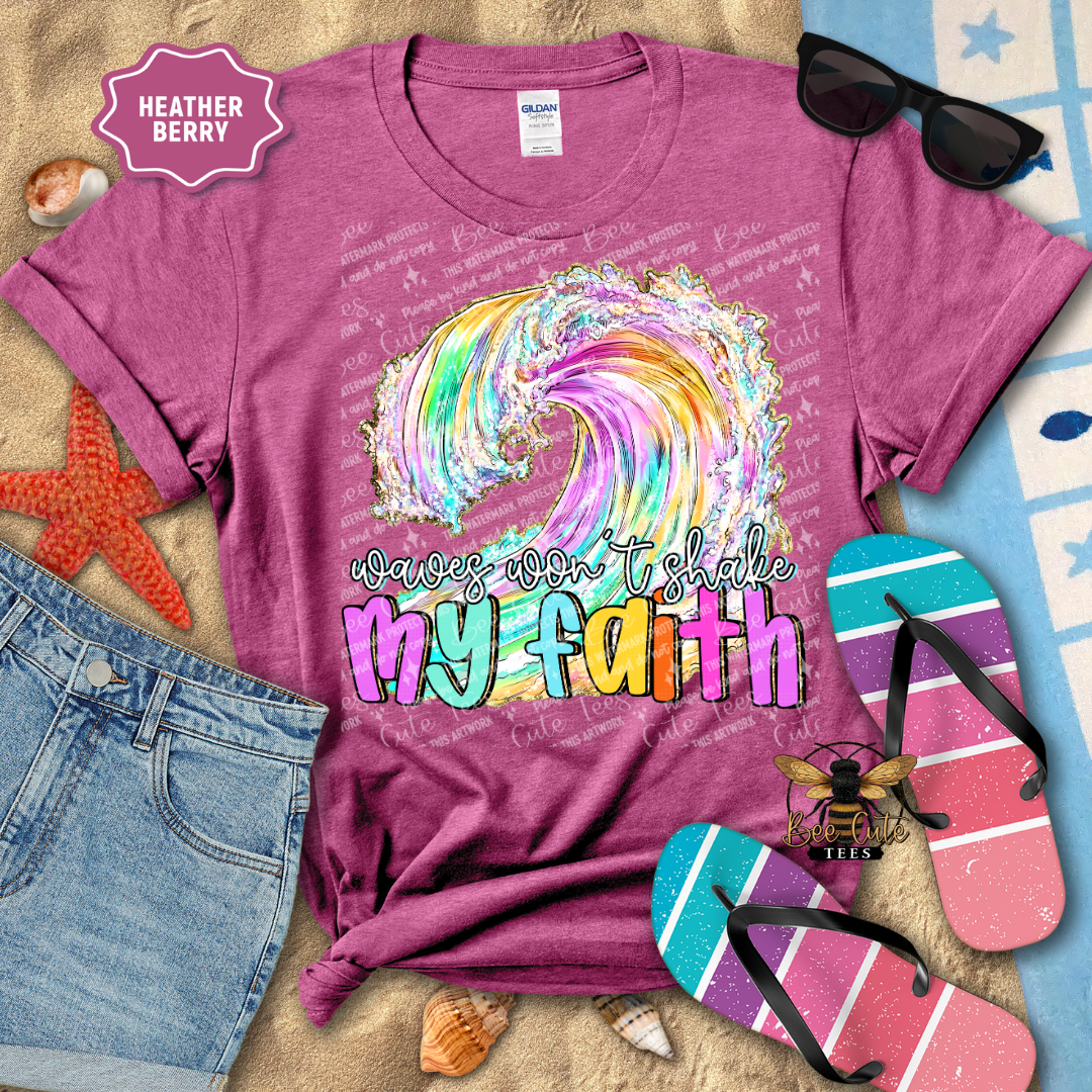 Purple t-shirt with colorful wave design and text 'waves won't shake my faith' on a beach-themed background.